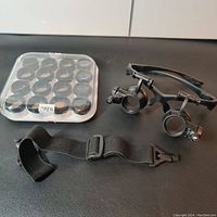 Set of all components including magnifying glasses frame, 8 lenses in carrying case, and black adjustable strap