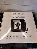 Closed DUCLUS Photography Light Box package showing the product image and listed features.