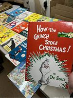Image showing the book 'How The Grinch Stole Christmas' prominently with other Dr. Seuss books laid out on a table.