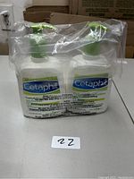 Two bottles of Cetaphil DailyAdvance Lotion, 18 fl oz each, wrapped together in clear plastic packaging with green pump tops visible. Front labels show branding and product details.
