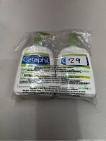 Two brand new Cetaphil lotion bottles sealed together in clear plastic packaging, front view showing product label and size.