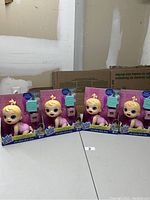 Four Baby Alive dolls in original packaging, displayed side by side on a table.