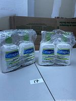 Four Cetaphil Daily Advance Lotion pump bottles shrink-wrapped together in clear plastic, visible front side of bottles with Cetaphil logo and product details.