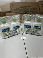 Two pairs of Cetaphil lotion bottles sealed in clear plastic packaging, showing front labels and pump tops.