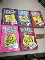 Five Dork Diaries books laid out on a table, showing front covers and title text clearly.