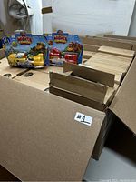 Overview of several boxes containing 72 new Mighty Express motorized train toys by Spin Master, featuring packed toys inside.