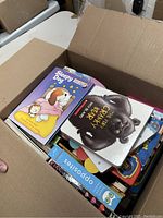 Open box showing colorful kids board books including 'Sleepy Dog' and 'The Cranky Bear'