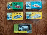 Photo showing all five boxed 1:43 scale Vanguards die cast models arranged on wood surface