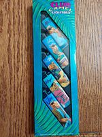 Original box containing five vintage Club Camel cigarette lighters, each with illustrated male character names visible through clear window.