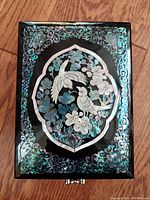 Top view of the vintage Eastern Asian jewelry box showing detailed mother of pearl bird and butterfly inlay design on the lid.