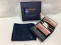 Opened compact showing two blush shades, brush, and mirror with matching cloth pouch and outer box.