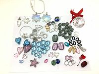 Full collection of Swarovski crystal beads and charms arranged on white surface including various shapes, sizes, and colors