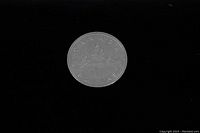 Reverse side of the coin showing the Voyageur and Indigenous person in canoe design with inscriptions.