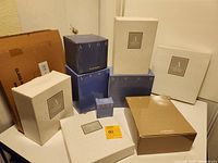 Full view of all 10 boxed Avon Hummingbird Crystal Collection items arranged together showing various sized boxes labeled with Avon branding and collection names.