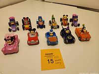 Eleven Disney character diecast cars arranged in rows showing full lot