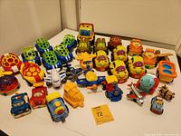 Full view of the assortment of 36 toy planes, trains, and automobiles showing various styles, colors, and sizes mostly plastic with some wooden pieces. Toys show signs of use.