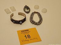 Full lot showing all jewelry items including pendants, bracelets, white stones, and picture pendant.