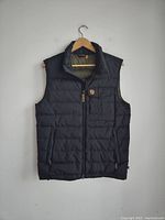 Front view of navy blue quilted vest with zip closure and pockets