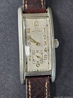 Front view of vintage Westfield tank watch showing rectangular silver case, off-white dial with gold-tone Arabic numerals and subsidiary seconds dial. Brown leather strap visible.