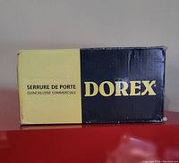 Photo of the Dorex branded box with product name and description in French and English, indicating it is a commercial door lock.