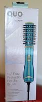 Box displaying the Quo Beauty by Conair Hot Air Brush with 1.5-inch frizz protection barrel.