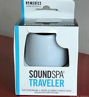 Front view of the boxed Homedics SoundSpa Traveler sleep sound machine showing white cylindrical device through cutout window.