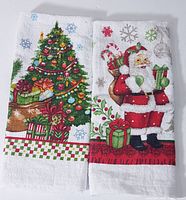 Two Christmas-themed tea towels side-by-side, one with a Christmas tree and presents, the other with Santa Claus holding gifts.