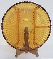 Front view showing full amber divided dish with scalloped edge and four clear sections.
