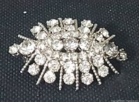 Close-up front view of the vintage clear rhinestone brooch showing clustered clear stones and silver-tone accents.
