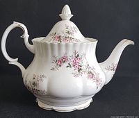 Front and left side view of bone china tea pot with floral lavender rose pattern and gold trim, showing scalloped base and ornate handle.