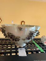 Side view of large ceramic bowl showing applied faux fungi clusters and scalloped top edge.