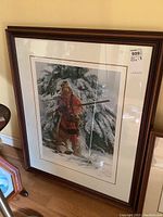 Framed print showing hunter in winter clothing in snowy forest.