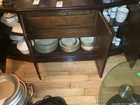 Overall view of stacked plates and bowls on sideboard shelves