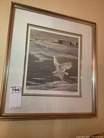 Framed signed art print by Robert Bateman depicting a snowy owl in flight over a snowy landscape. Signature and edition number visible.