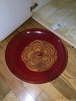 Top view of the Waterford Evolution glass bowl showing the red color and central floral swirl pattern.