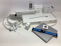 Overview of all Apple peripherals including keyboard box, Pencil, SuperDrive, iPod receiver, watch band, Apple TV remote, power bricks, and new off-brand earpods and case.