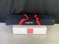 Two items included: a black fabric carry bag with red straps and Audyssey branding, and a white box with EQ logo.