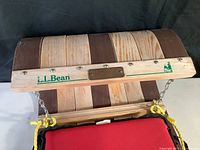 Close-up of wooden curved backrest with L.L.Bean branding and metal plate