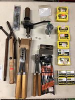 Full view of reloading tools, projectile molds, bullet boxes, and brass tapper