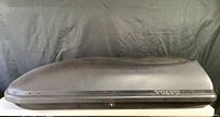 Side view of black Volvo-branded Thule rooftop cargo box showing general shape and logo placement.