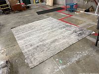 Photo showing the full rectangular IKEA area rug spread on the floor, showcasing its size and subtle gray abstract pattern.