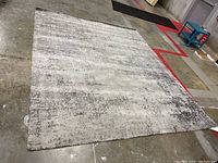 Full view of the rectangular IKEA area rug spread out on a concrete floor, showing its overall size and pattern.