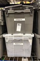Two large plastic storage totes labeled "Blankets" stacked on a shelf, totes closed showing labels