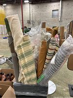 Wide view showing multiple bolts of fabric in a bundle on a stand in a warehouse setting.