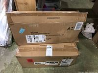 Three cardboard boxes containing floating shelves as packed for shipment or storage.