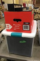 Plastic tote container with teal latch storing the photo frames and posters