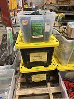 Three stacked bins: clear bin on top with green-wire string lights, two black bins with yellow lids below labeled 'foundation string lights' containing black wire work light stringers