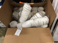 Open box showing multiple stacks of white 12oz Solo cardboard takeout soup bowls and lids packed inside.