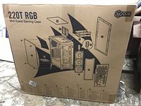 View of the cardboard box with exploded diagram of the gaming case parts and labeled '220T RGB Mid-Tower Gaming Case' with iCUE logo.
