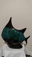 Front side view of the Blue Mountain Pottery trout ceramic fish figurine, showing the blue-green glazed body and black base and fins.